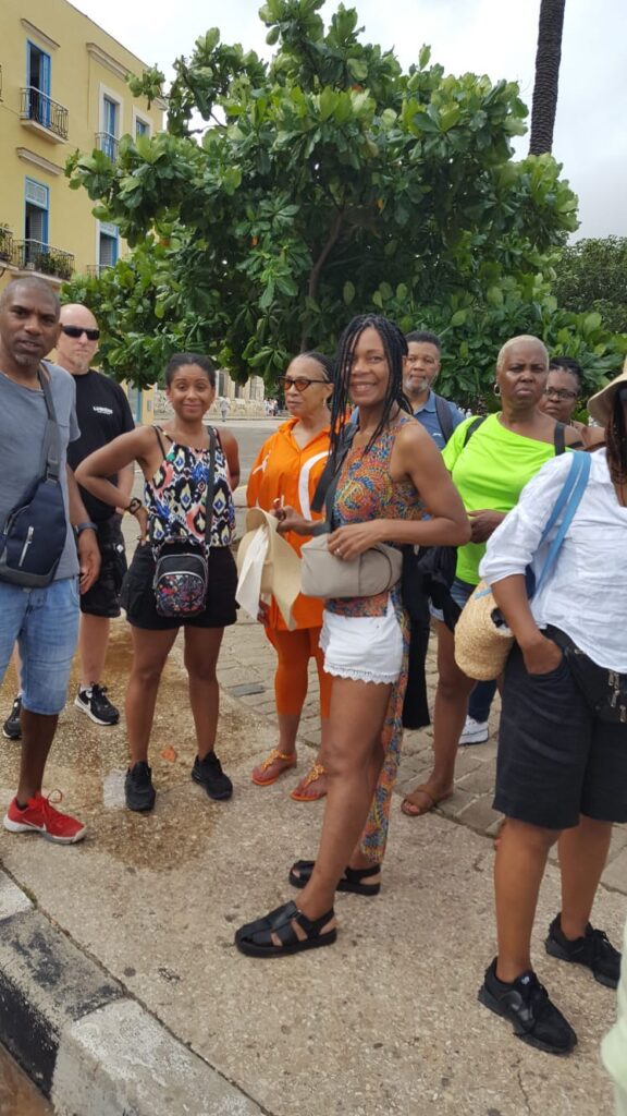 Travellers pose during Havana classic car tour