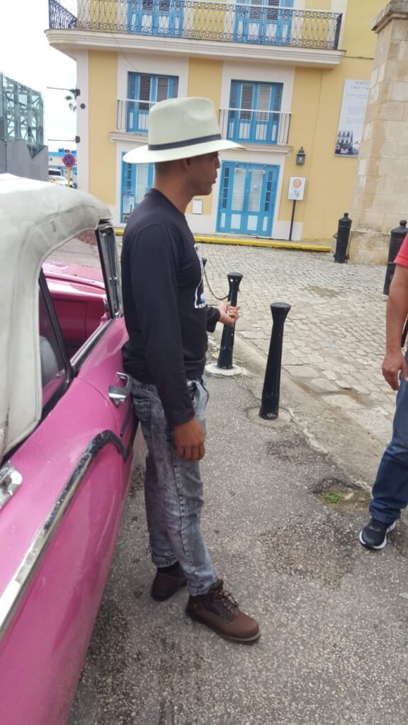 Driver relaxes during Havana classic car tour