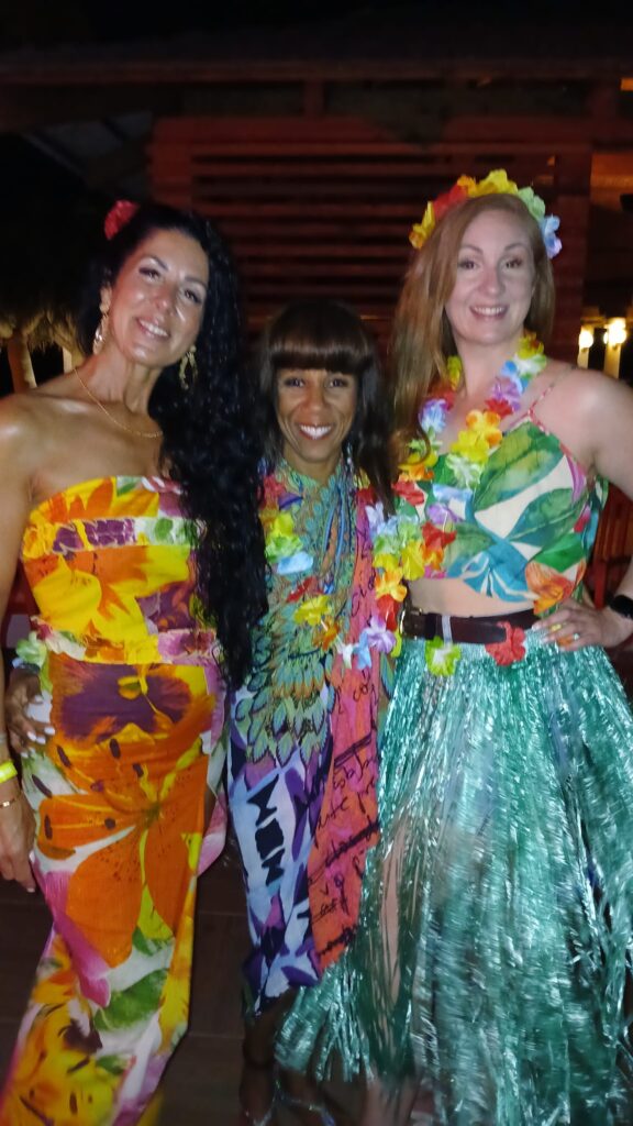 Carol poses with here Urban Pilates travellers at SALSOGA '24 Hawaii night