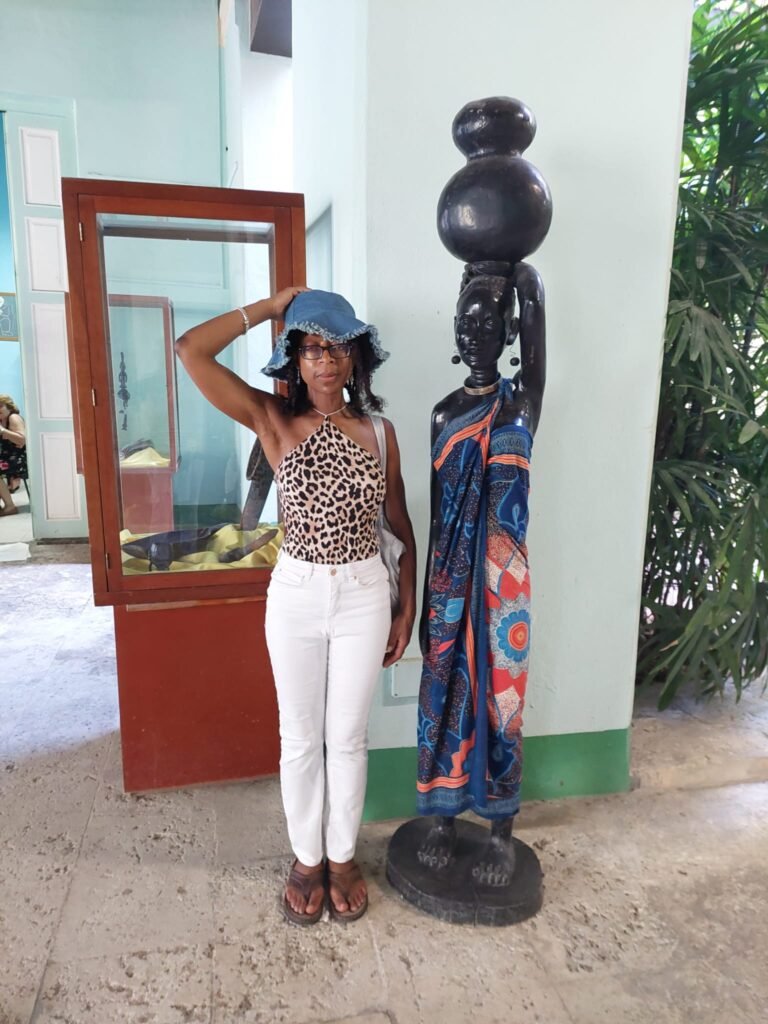 Brenda poses beside Havana carving in museum