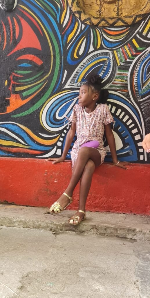 Young Cuban girl sits besides Havana street art