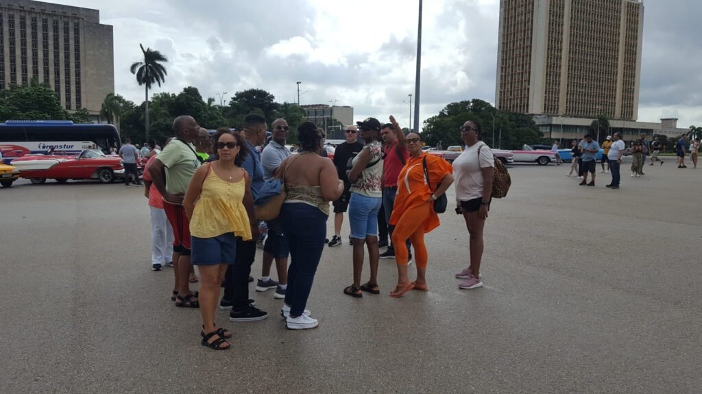 Travellers during classic car town receiving knowledge in Revolutionary Square, Havana