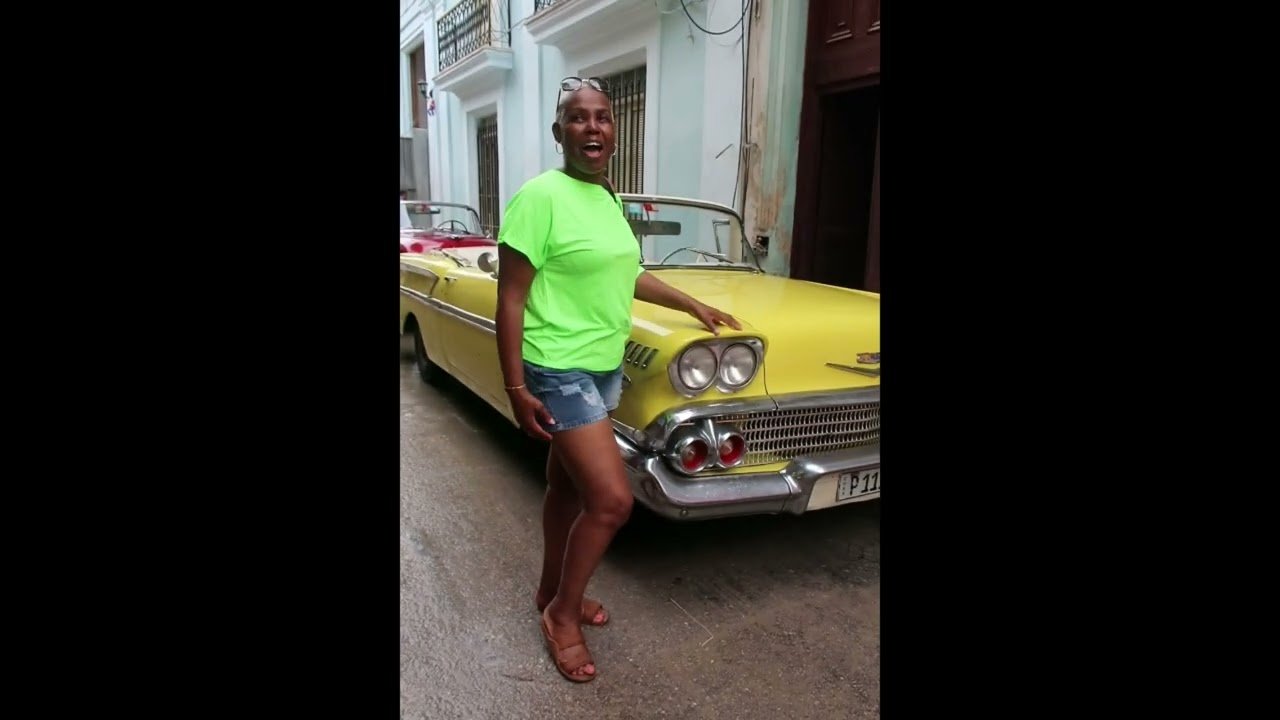 A Taste of Salsa classic convertible car convoy making some noise as that get ready to leave on the Havana city tour, whilst travellers make a pose.